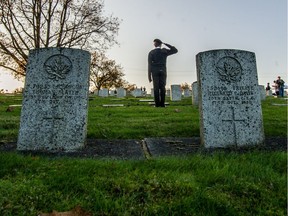 A New Westminster St. John Ambulance cadet salutes the military gravestones for the inaugural No Stone Left Alone commemoration event at Fraser Cemetery in New Westminster on Sunday.