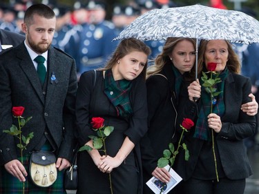 Drew Davidson, from left to right, and his sisters Fay and Dina stand with their mother Denise as they watch the casket of Abbotsford Police Const. John Davidson, who was killed in the line of duty on Nov. 6, being loaded into a hearse after a memorial in Abbotsford, B.C., on Sunday November 19, 2017. THE CANADIAN PRESS/Ben Nelms ORG XMIT: VCRX225
BEN NELMS,