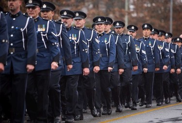 Abbotsford Police officers walk in formation behind the funeral procession carrying the body of Abbotsford Police Const. John Davidson, who was killed in the line of duty Nov. 6, on their way to a memorial service in Abbotsford on Sunday, Nov. 19, 2017.