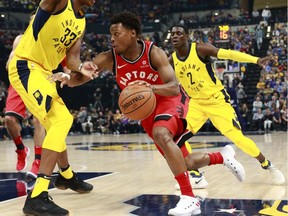 Toronto Raptors guard Kyle Lowry dribbles the basketball while defended by Indiana Pacers center Myles Turner (33) and guard Darren Collison (2) during the first half of an NBA basketball game, Friday, Nov. 24, 2017, in Indianapolis. Indiana won 107-104.