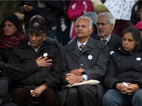 Mukand Lal Pallan, (left), father of Manjit Virk (centre), and Amarjit Pallan (right) take comfort as supporters speak at a memorial marking 20 years since the swarming and bullying death of 14-year-old Reena Virk at the Craigflower Schoolhouse in Victoria, B.C., on Tuesday, November 14, 2017.