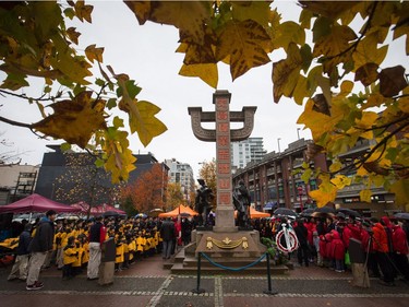 People gather at a monument honouring Chinese veterans and Chinese railway workers for a Remembrance Day ceremony marking the sacrifices of the early Chinese pioneers and Chinese-Canadian military veterans, in Chinatown in Vancouver, B.C., on Saturday November 11, 2017.
