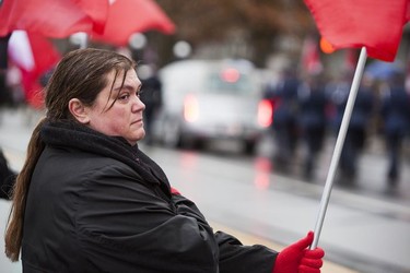 An unidentified woman pays her respects as a hearse carrying the body of Abbotsford Police Const. John Davidson makes its way through the streets of Abbotsford on Sunday, Nov. 19, 2017. Davidson was shot and killed in the line of duty on Nov. 6.