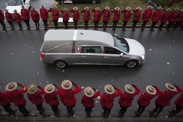 RCMP constables salute the hearse carrying the body of Const. John Davidson after his service in Abbotsford on Nov. 19, 2017.