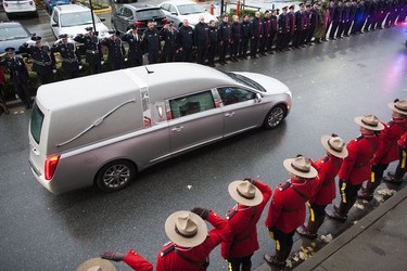 RCMP constables salute the hearse carrying the body of Const. John Davidson after his service in Abbotsford on Nov. 19, 2017.