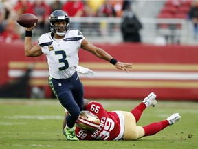 Seattle Seahawks quarterback Russell Wilson (3) throws while being tackled by San Francisco 49ers defensive tackle DeForest Buckner (99) during the first half of an NFL football game Sunday, Nov. 26, 2017, in Santa Clara, Calif.