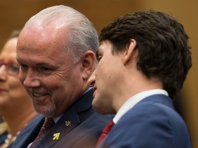 British Columbia Premier John Horgan listens to Prime Minister Justin Trudeau before they addressed the crowd at the Women Deliver kickoff event in Vancouver, B.C., on Thursday, November 16, 2017.