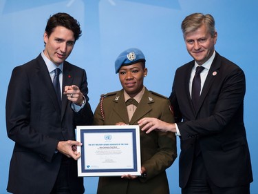 Prime Minister Justin Trudeau, left, and United Nations Under-Secretary-General for Peacekeeping Operations Jean-Pierre Lacroix, right, present the 2017 UN Military Gender Advocate of the Year award to Major Seitebatso Pearl Block, of The South African National Defence Force, during the 2017 United Nations Peacekeeping Defence Ministerial conference in Vancouver, B.C., on Wednesday November 15, 2017