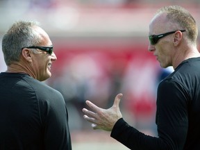 Jeff Reinebold, left, consults with Jeff Garcia in 2014. Reinebold has been hired by the B.C. Lions as their special-teams co-ordinator.