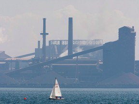 A sailboat sails past the Stelco plant in Hamilton, Ont.