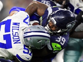 Mike Davis (39) of the Seattle Seahawks is tackled by Damien Wilson (57) of the Dallas Cowboys in the second half at AT&T Stadium on Dec. 24 in Arlington, Tex.