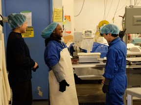 Surrey student Claudine Dushimirimana shares a laugh with coworkers at her job at Blundell Seafoods in Richmond.