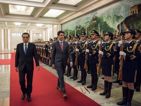 Justin Trudeau and Chinese Premier Li Keqiang walk past paramilitary guards during a welcome ceremony at the Great Hall of the People in Beijing.