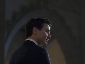 Prime Minister Justin Trudeau listens to a question from the media in the foyer of the House of Commons following the release of an ethics report in Ottawa on Wednesday December 20, 2017.