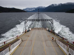 A crew member walks on the vehicle deck of the B.C. Ferries' vessel Island Sky while travelling on the waters off the Sunshine Coast. A report commissioned by the former B.C. Liberal government has concluded that a fixed link isn't feasible.