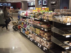 Various brands of bread sit on shelves in a grocery store in Toronto on Nov. 1. The Competition Bureau's investigation into allegations of bread price-fixing includes at least seven companies, including Loblaw and Weston Bakeries, according to court documents.