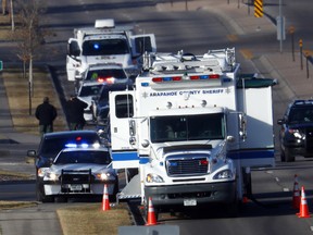 A long line of police vehicles stand on County Line Road near the scene of shooting Sunday, Dec. 31, 2017, in Highlands Ranch, Colo.