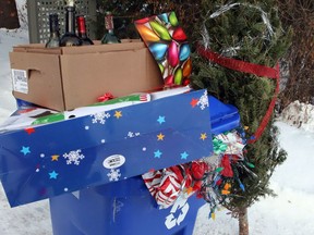 A blue recycling bin is shown with Christmas wrapping paper, bottles, along with other items that get thrown out after Christmas in Gatineau, Que, across the river from Ottawa, Tuesday, December 26, 2017. Canadians will send more than 540,000 tonnes of wrapping paper and gift bags to the garbage dump this year, and Christmas presents are the biggest culprit.