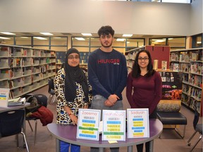 Twice a week at Queen Elizabeth Secondary as many as 16 volunteer student tutors set up shop in the library, each with a card on their stall advertising the subjects in which they specialize. From the left, Zaeema Khan, Mahmoud Kittaneh and Sadiyah Atick meet for the peer tutoring program.