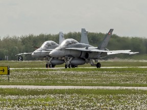 A Royal Canadian Air Force maintainer directs two CF-188 Hornets off the runway after they land during Exercise MAPLE FLAG on June 1, 2016.