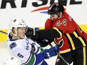 Vancouver Canucks' Brock Boeser, left, is hit by Calgary Flames' Matt Bartkowski during first period NHL pre-season action in Calgary in September.