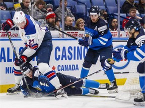 USA's Riley Tufte battles for the puck with Finland's Urho Vaakanainen, bottom, Janne Kuokkanen, centre, and Kasper Kotkansalo, right, during the first period of IIHF World Junior Championship preliminary hockey action in Buffalo, N.Y. Sunday December 31, 2017.