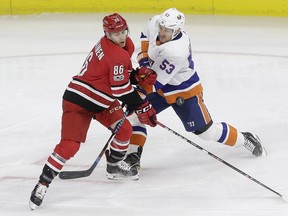 Carolina Hurricanes' Teuvo Teravainen, left, and New York Islanders' Casey Cizikas battle for the puck during an NHL game in Raleigh, N.C., on Nov. 19.