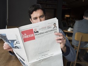 A man reads the final print edition of the French language newspaper La Presse at a coffee shop in Vaudreuil-Dorion, west of Montreal, Saturday, December 30, 2017.