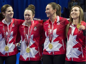 Skip Rachel Homan from Ottawa (far right) holds up her medal as lead Lisa Weagle (left) and third Emma Miskew (second from right) turn to second Joanne Courtney as she cries on the podium after being presented with their medals following the Olympic curling trials final on Sunday, Dec. 10, 2017 in Ottawa.