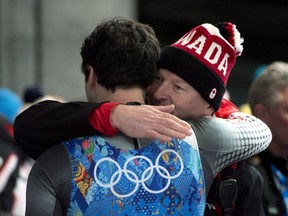 Canada's Sam Edney (left) is consoled following his team's fourth-lace finish in the Luge Team Relay at the Sochi Winter Olympics in Krasnaya Polyana, Russia, Thursday, Feb. 13, 2014. Canada's luge relay team is set to gain a bronze medal from the Sochi Olympics.