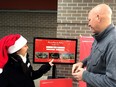 Port Coquitam Mayor Greg Moore, right,  tries out Metro Vancouver's  new Merry Memory Maker app Saturday at Hyde Creek Recreation Centre in Port Coquitlam.