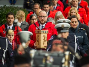 Curtis Jones carries the ashes of Jay Piggot as the life of the North Shore Rescue team member is remembered at the Capilano Rugby Clubhouse in North Vancouver, BC, December 18, 2017.