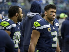 Seattle Seahawks quarterback Russell Wilson, right, and wide receiver Doug Baldwin, left, stand on the sideline during the second half of an NFL football game against the Los Angeles Rams, Sunday, Dec. 17, 2017, in Seattle.