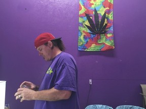 In this Tuesday, Oct. 3, 2017, photo, Thomas Grier works as a "bud tender" at Canna Can Help Inc., a medical marijuana dispensary in Goshen, Calif. Labor unions are vying to represent California cannabis workers when a new law takes effect in 2018 legalizing the sales of recreational marijuana.