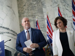 Premier John Horgan is joined by Minister of Energy Michelle Mungall after giving the green light on continuing construction on the controversial Site C Dam project during a press conference in Victoria on Monday.