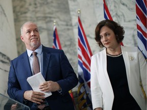 Premier John Horgan is joined by Minister of Energy Michelle Mungall after giving the green light on continuing construction on the controversial Site C Dam project during a press conference in Victoria, B.C., on Monday, December 11, 2017.