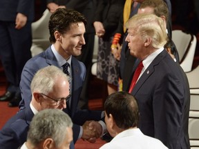 Canadian Prime Minister Justin Trudeau, left, shakes hands with U.S. President Donald Trump as they take their seats at the opening ceremony of the 31st ASEAN Summit in Manila, Philippines on Monday, Nov. 13, 2017.