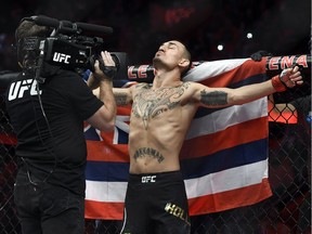 Max Holloway, stands in front of the state flag of Hawaii, as he prepares to fight Jose Aldo of Brazil during a UFC 218 featherweight mixed martial arts bout, Sunday, Dec. 3, 2017, in Detroit.