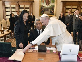 Pope Francis exchanges gifts with Ecuador's President Lenin Moreno, center, and his wife Rocio Gonzalez Navas during a private audience at the Vatican, Saturday, Dec. 16, 2017.