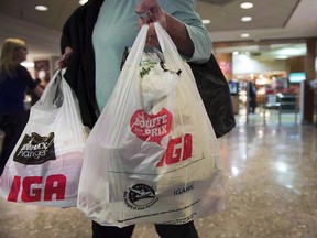 A woman leaves a grocery store Friday, May 15, 2015 in Montreal. Victoria is the latest Canadian city to move ahead with a ban on single-use plastic shopping bags.