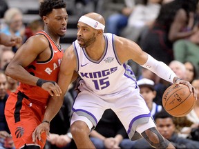 Kings guard Vince Carter (right) looks to move around Raptors guard Kyle Lowry during first half NBA action in Toronto on Sunday, Dec. 17, 2017.