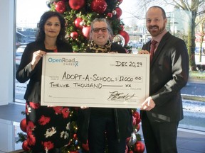 Brad Beckett, general manager of OpenRoad Audi Boundary, and Sharon Rupal, general manager of OpenRoad Port Moody, present Shelley Fralic (centre) with a cheque for $12,000 for the Adopt-A-School fund.