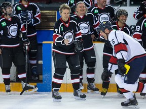 Jim Cuddy throws a glove in front of a racing Brad Dalgarno   during a skill contest as hockey and music join forces for charity, as Canadian musicians and NHL veterans hit the ice for the 2017 JUNO Cup.