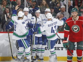 Brock Boeser, centre, celebrates his first career NHL goal against the Minnesota Wild during a March 25, 2017 game at the Xcel Energy Center in St. Paul, Minn.