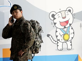 A South Korean soldier uses mobile phone at the 2018 PyeongChang Winter Olympic and Paralympic Games PR booth on January 5, 2018 in Seoul, South Korea.