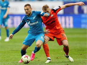 Yohan Mollo, left, of FC Zenit St. Petersburg and Roman Yemelyanov of FC Ural Ekaterinburg vie for the ball during the Russian Football League match between FC Zenit St. Petersburg and FC Ural Ekaterinburg at St. Petersurg stadium in 2017 in St. Peterburg, Russia.