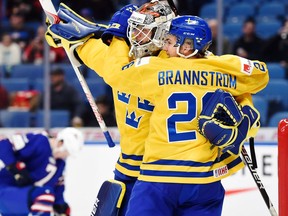 Filip Gustavsson of Sweden and Erik Brännström of Sweden celebrate after winning a semifinal game against the U.S. on Jan. 4, 2018