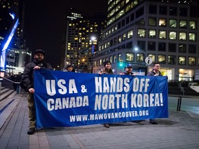 Protesters carry a banner while marching outside the site of a summit on North Korea being hosted by Canada and the U.S., in Vancouver, B.C., on Monday January 15, 2018. Foreign ministers from 20 countries are meeting Tuesday to discuss security and stability on the Korean Peninsula.