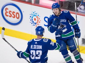 Brock Boeser and Henrik Sedin celebrate Boeser's first goal against the Kings.