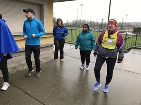Vancouver Sun Run leader Tammy Bozzard, right, leads her Township of Langley runners and walkers through a morning warm-up exercise at McLeod Athletic Stadium.